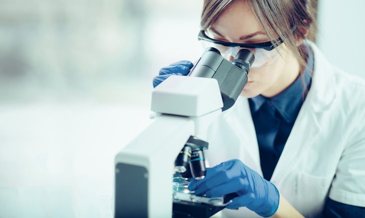 Scientifique de laboratoire féminin à l'aide d'un microscope