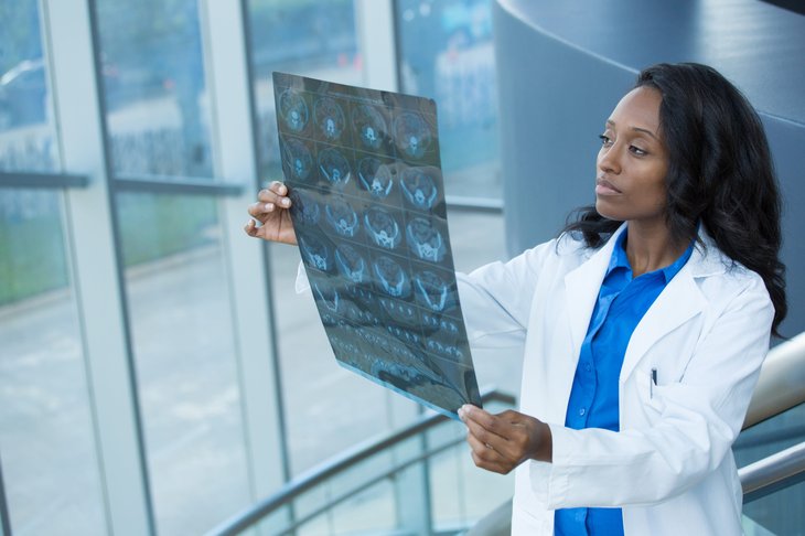 Femme médecin regardant X-ray ou autre test d'imagerie