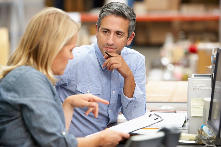 Les employés d'entrepôt parlent à un bureau