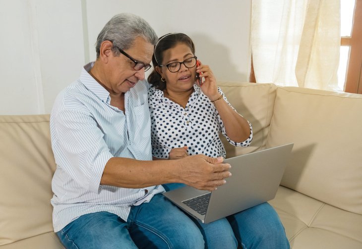 Couple plus âgé surfant sur internet sur un ordinateur portable