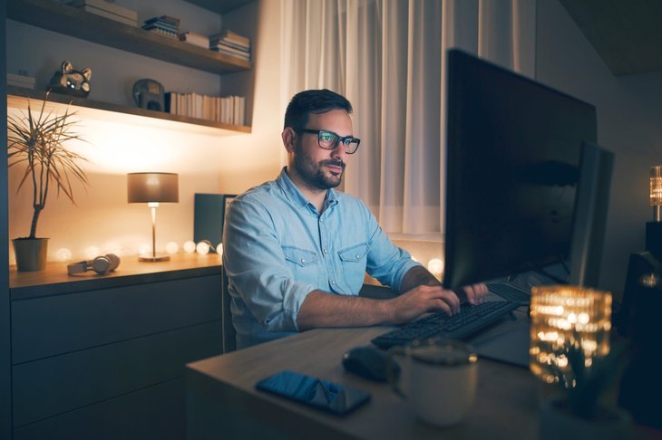 Homme travaillant à distance sur ordinateur la nuit