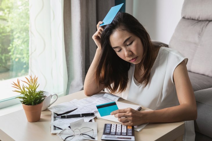 Femme stressée regardant les factures et la carte de crédit