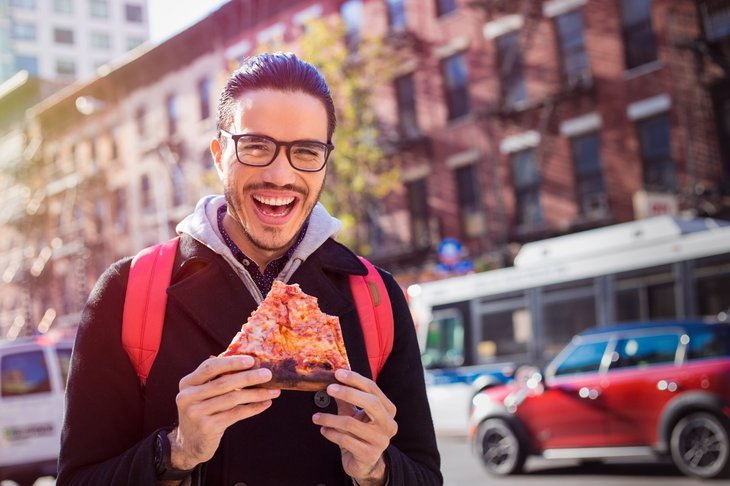Homme mangeant de la pizza à New York