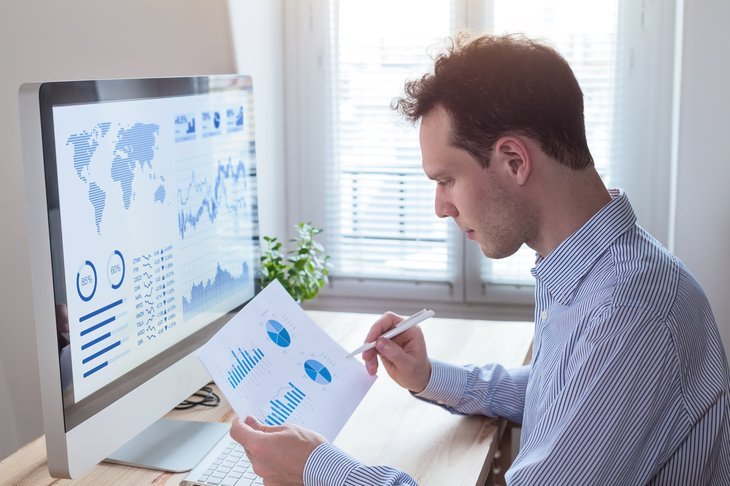 A man studies financial data at his computer